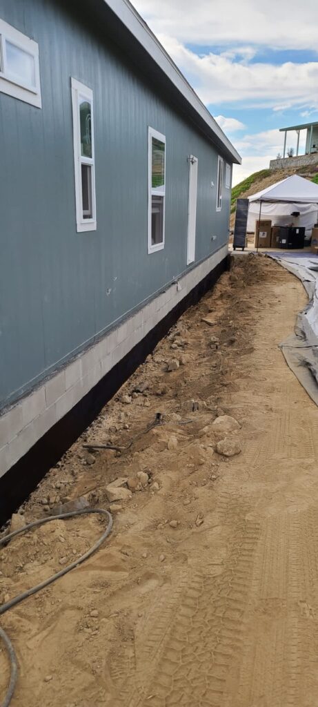 Side yard trench prepared next to manufactured home