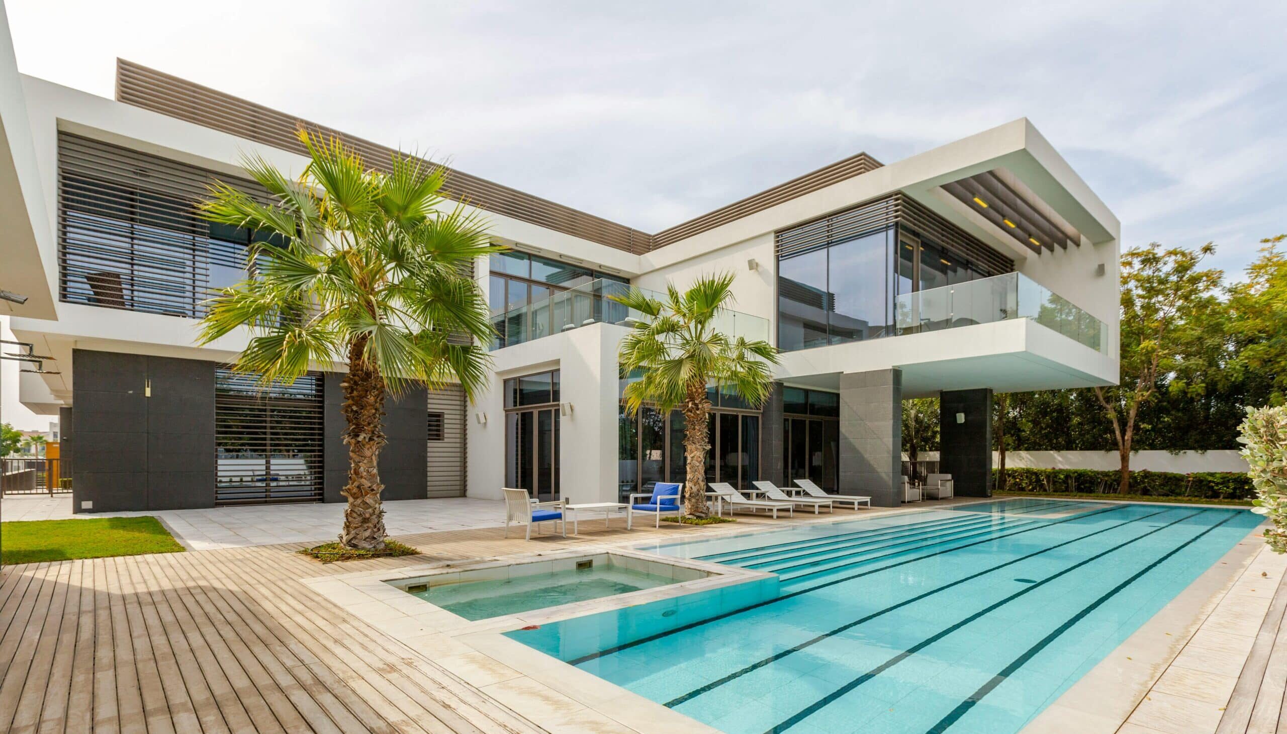 Explore this luxurious modern villa in Dubai with a stunning swimming pool and palm trees.